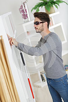 blind man with white stick and dark glasses at home