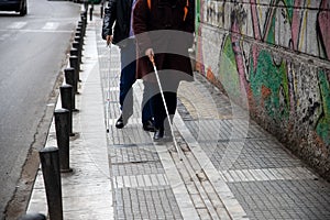 Blind man and woman walking on the street