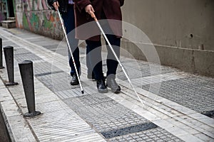 Blind man and woman walking on the street