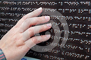 A blind person reads braille, female hand