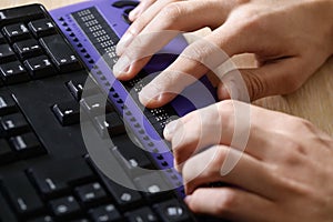 Blind person using computer with braille computer display photo