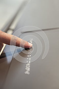 Blind reading text caption in braille language at museum