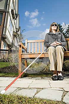 Blind woman sitting on a bench