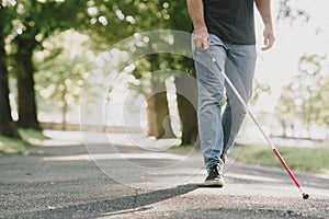 Blind young man in black sunglasses walking outdoors