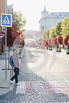 Blind young man crossing road