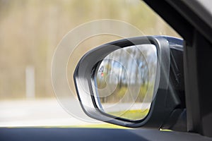 Blind zone monitoring sensor on the side mirror of a modern car