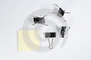 Blinder clips and memo pad on white background