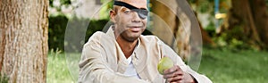 A blindfolded African American man holds