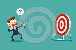 Blindfolded businessman shooting arrow