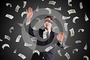 Blindfolded Businessman Standing Under Money Rain