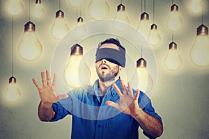 Blindfolded man walking through light bulbs searching for bright idea