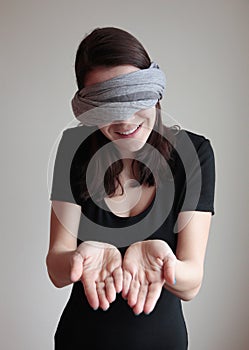 Blindfolded young woman showing palms