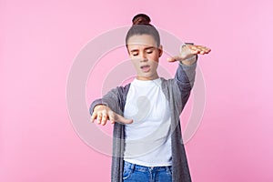 Blindness. Portrait of brunette teenage girl reaching out hands to find way. indoor studio shot isolated on pink background