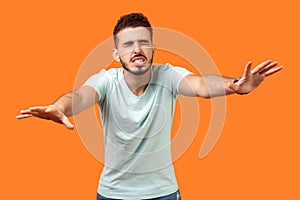 Blindness! Portrait of disoriented brunette man walking with eyes closed. isolated on orange background photo