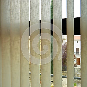 Blinds with adjustable vertical slats made of fireproof fabric to regulate ambient light