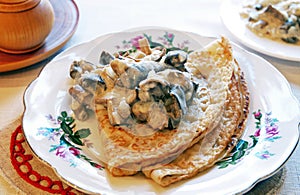 Blini with mushrooms in white sauce photo