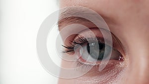 Blinking, half and eye for health of vision, closeup and sight for looking in white background. Studio, person and adult