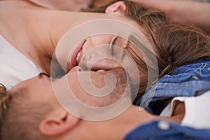 Blissful young love. A young couple lying on the living room floor close together with affection.