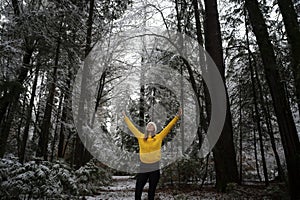 Feliz mujer joven celebra vida de pie en el invierno Bosque 