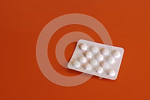 Blister of aspirin tablets on red background