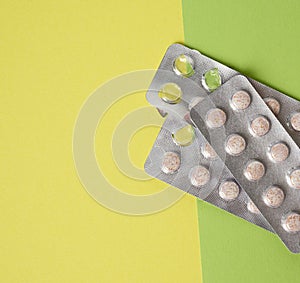 Blister packaging with round pills on green background