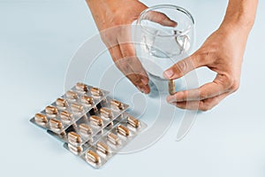 Blister with tablets for dietary and glass of water. Diet with biologically active supplement. Proper nutrition concept