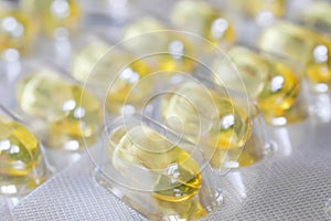 Blisters with golden fish oil capsules. Pharmaceuticals and Pharmacology. Medicines for the prevention of viral diseases. Close-up