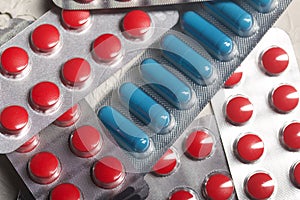 Blisters with red and blue tablets. On a light background. Close-up