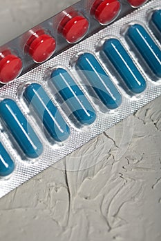 Blisters with red and blue tablets. On a light background. Close-up