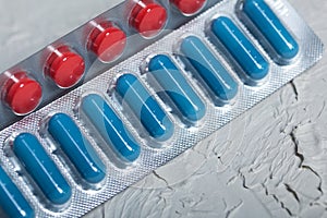 Blisters with red and blue tablets. On a light background. Close-up