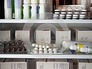 Blisters, tubes, boxes and other packages with medicines are neatly arranged on the shelves of the refrigerator.