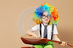 Blithesome children. Happy clown boy in large neon colored wig p