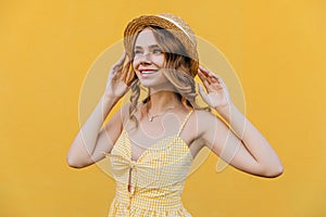 Blithesome white girl in straw hat dreamy looking away. Studio portrait of refined pretty lady wear