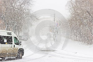 Blizzard, mist and snowfall in city, cars on sleet road, poor visibility, winter bad weather