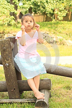 Bloated girl sitting on wooden construction photo