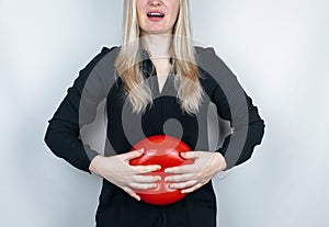 Bloating and flatulence concept. The woman holds a red balloon near the abdomen, which symbolizes bloating. Intestinal tract and d