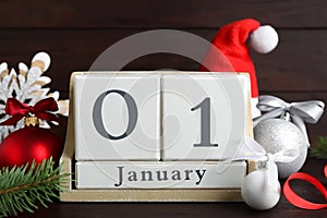 Block calendar and Christmas decor on wooden table. New Year celebration
