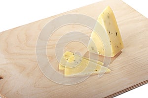 block of cheese with cut pieces on a cutting board, isolated on white background