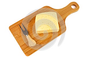 Block of cheese on cutting board with a knife, isolated on white background