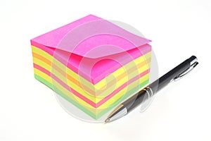 Block of colored sticky notes and a pen isolated on white background with copy space for your text