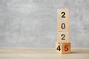 block flipping 2024 to 2025 text on table. Resolution, strategy, plan, goal, motivation, reboot, business and New Year holiday photo