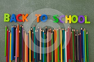 Block letters and color pencils arranged on chalkboard