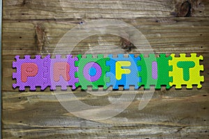 Block letters and word profit with wood background