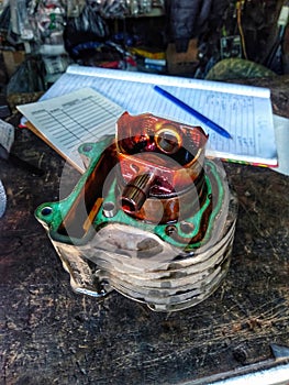 The block and piston of an automatic motorcycle that was damaged because the engine oil had risen to the piston