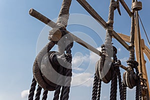 Block and tackle rigging on an old tall ship before blue sky, spliced and wrapped rope lines