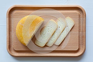 Block of tasty cheese on cutting board
