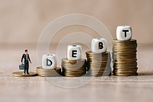 Block word debt on pile of coins with business man, Payment of taxes and of debt to the state, Concept of financial crisis and