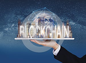 Blockchain business and technology, Hand holding digital tablet with buildings and blockchain technology. Element of this image ar