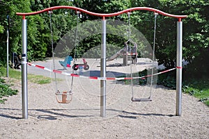 Blocked swing, closed public children`s playground,coronavirus lockdown
