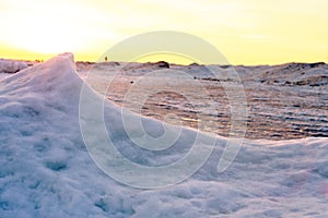 Blocks of ice on the seashore at sunset